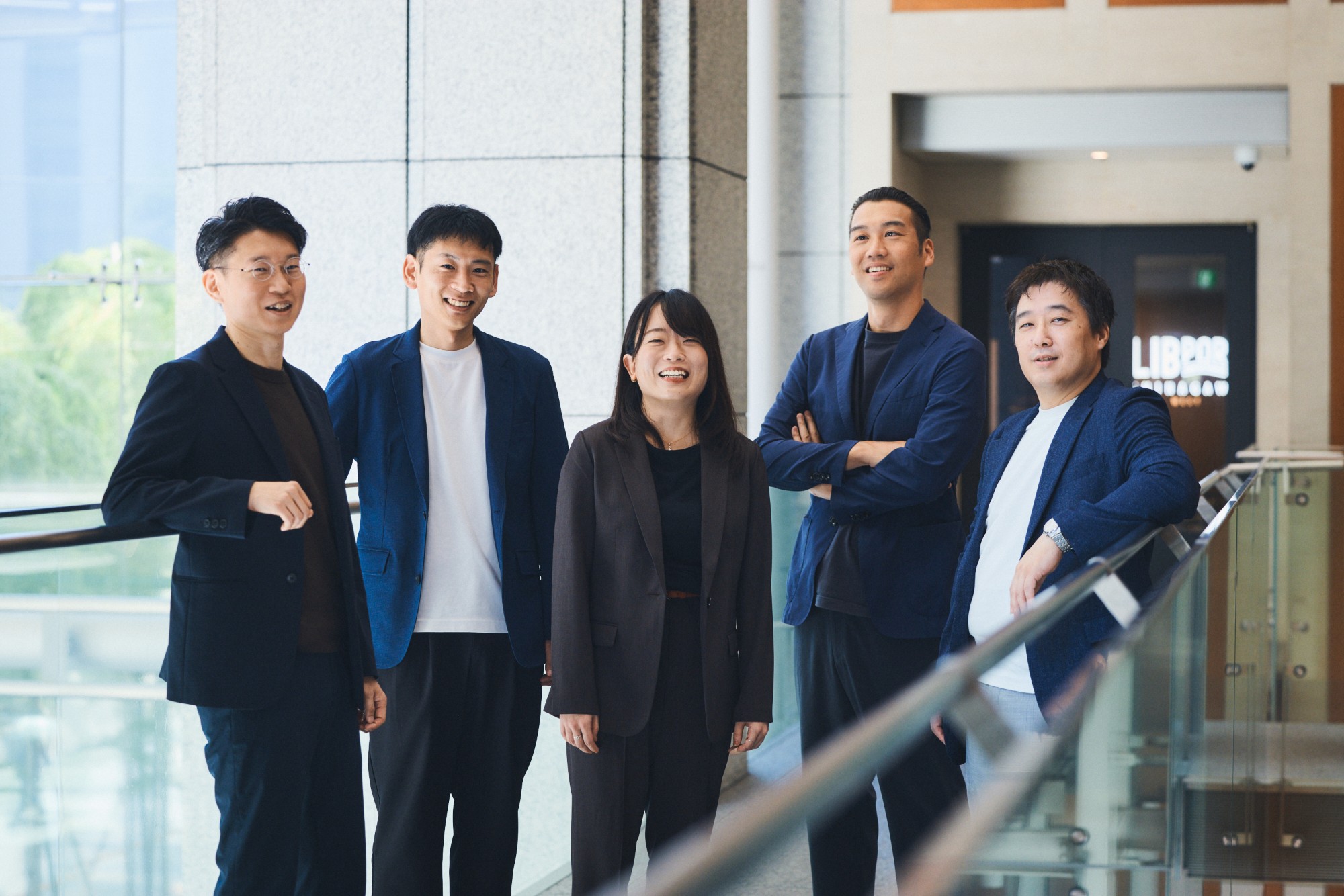 笑顔で並ぶ5人の社員