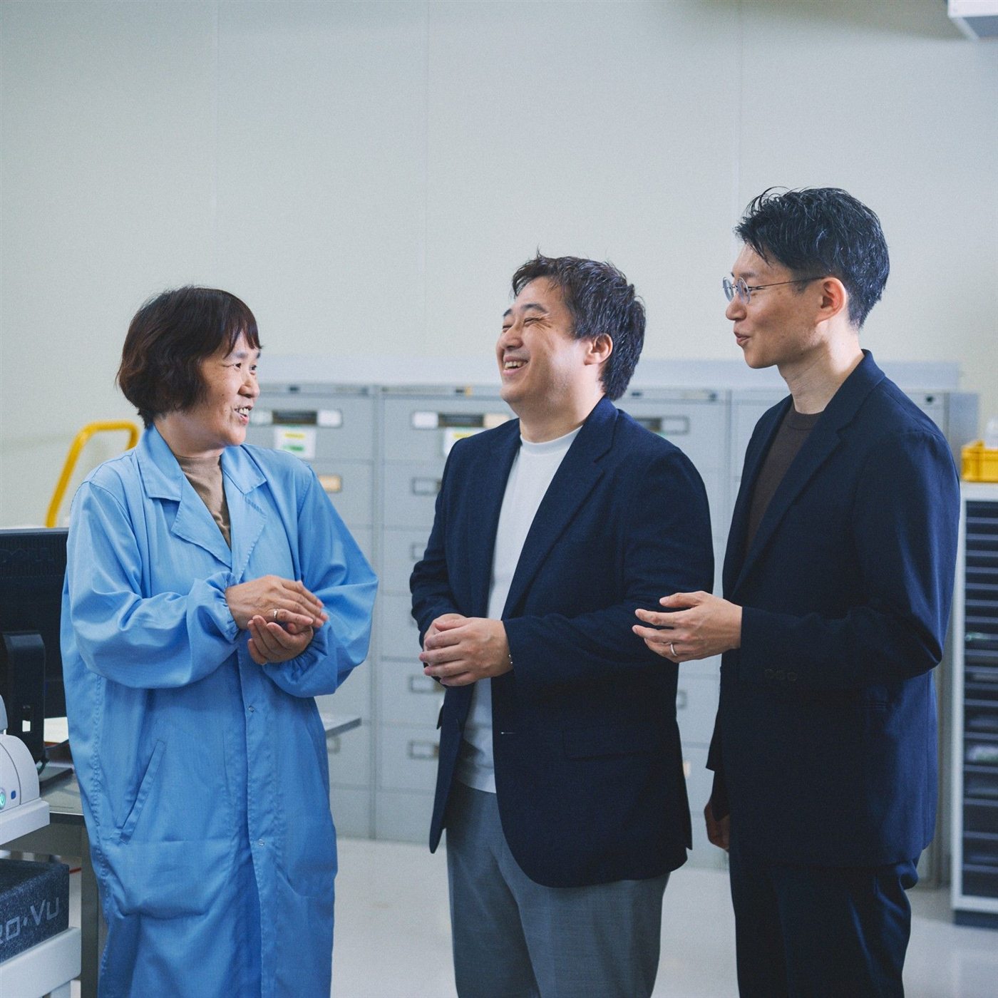 青い作業着の社員と談笑する社員